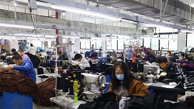 Skilled operators sewing activewear on the production line.